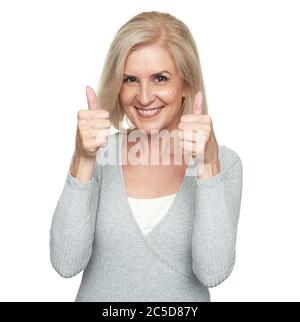 Donna bionda di media età sorridente e mostrante pollici in su Foto Stock
