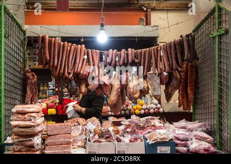 SUBOTICA, SERBIA - 28 MARZO 2019: Salsicce secche, chiamate Kulen kobasica e altri salumi appesi su una bancarella nel mercato di Subotica, chiamato bu Foto Stock