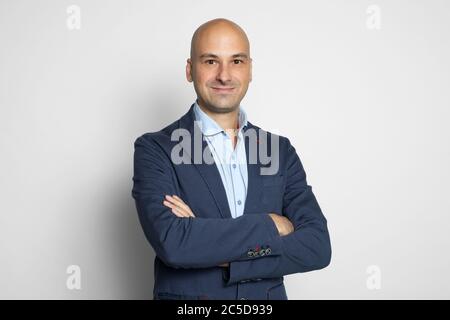 Allegro bell'uomo calvo che indossa abiti casual alla moda. Isolato su sfondo grigio studio Foto Stock
