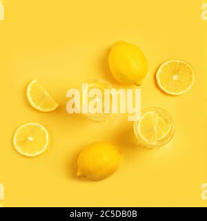 Disintossicare con limone su sfondo giallo. Limonata di agrumi. In estate, la frutta insisteva su Water.Fresh limone - modello. Disposizione piatta. Foto Stock