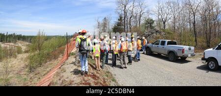 SUDBURY, ONTARIO, CANADA - MAGGIO 21 2009: Gruppo di lavoratori e geologi in cappelli duri e giubbotti ad alta visibilità in piedi su strada. Foto Stock