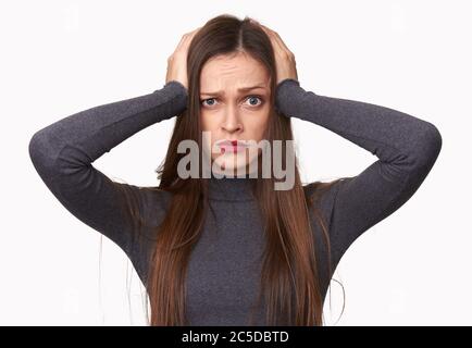 Donna scioccata tiene le mani sulla testa isolata su sfondo bianco Foto Stock