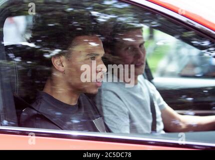 Monaco, Germania. 02 luglio 2020. Il nuovo arrivato del FC Bayern Leroy Sané (l) si siede sul sedile passeggero di una macchina mentre lascia il campo di allenamento del FC Bayern su Säbener Strasse. Il nuovo arrivato del FC Bayern Sané è arrivato a Monaco il giorno prima. Credito: Matthias Balk/dpa - NOTA IMPORTANTE: In conformità con le norme del DFL Deutsche Fußball Liga e del DFB Deutscher Fußball-Bund, è vietato sfruttare o sfruttare nello stadio e/o nel gioco le fotografie scattate sotto forma di sequenze di immagini e/o serie di foto di tipo video./dpa/Alamy Live News Foto Stock