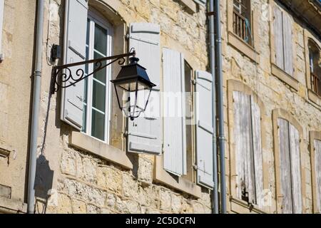 Lampada da strada in ferro battuto su muro di pietra a Lectoure, Gers, Francia Foto Stock