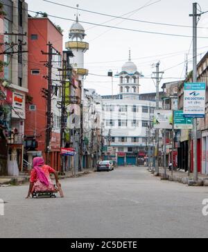 Guwahati, Assam, India. 2 luglio 2020. Una donna mendicante è alla ricerca di mezzi di sussistenza nella strada deserta di Fancy Bazar di Guwahati City. Fancy Bazar è la maggior parte della zona di mercato più trafficato di Guwahati, la capitale dello stato di Assam, India. UN ''˜blocco totale' di 14 giorni è iniziato in tutte le aree che rientrano sotto il distretto della metropolitana di Kamrup di Assam, compreso Guwahati dalle 19:00 del 28 2020 giugno, Nel tentativo di arrestare il numero crescente di casi di Covid-19 nello stato.secondo il reparto sanitario, il blocco, che sarà molto rigoroso durante i primi sette giorni con solo farmacie, ospedali e medi Foto Stock