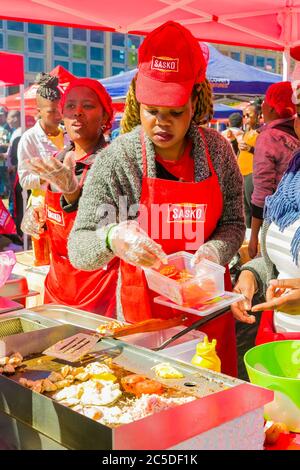 Soweto, Sudafrica - 8 settembre 2018: Diversi venditori africani che cucinano e servono vari piatti di strada a base di pane al festival all'aperto Foto Stock