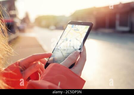 Concetto di mappe e navigazione Internet. Mani femminili che tengono uno smartphone con un'app Maps. Spazio di copia. Foto Stock