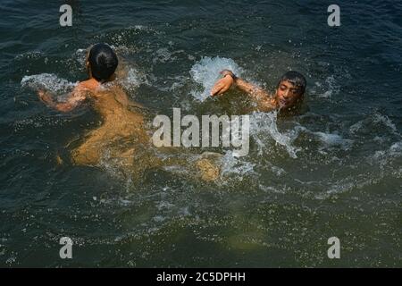 Srinagar, India. 02 luglio 2020. I ragazzi di Kashmiri si raffreddano in un ruscello per battere il caldo nelle calde giornate estive a Srinagar.mentre Kashmir è rimasto nella morsa delle condizioni climatiche calde e umide con la sua temperatura che si è elevata, la città di Srinagar ha visto il giorno più caldo di quest'estate con il mercurio che tocca 33 gradi Celsius. (Foto di Musaib Mushtaq/Pacific Press) Credit: Pacific Press Agency/Alamy Live News Foto Stock