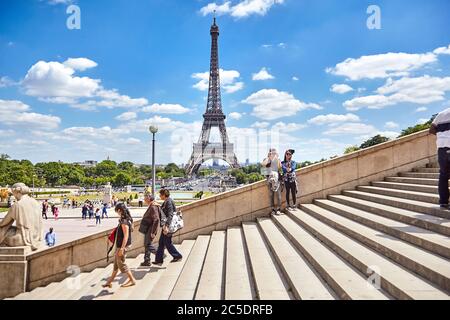 Parigi, Francia - 19 giugno 2015: Torre Eiffel in una giornata estiva di sole. I turisti vengono fotografati sullo sfondo delle attrazioni Foto Stock