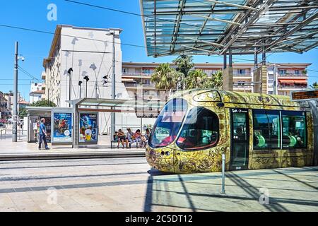 MONTPELLIER, FRANCIA - 24 giugno 2015: Trasporti pubblici urbani. Bellissima tram multicolore. Passeggeri a una fermata del tram. Piattaforma di atterraggio Foto Stock