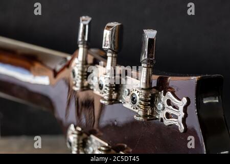 Tasti meccanici per la sintonizzazione della chitarra. Metal Strings UNA chitarra acustica sintonizzata. Lezioni di chitarra. Dettagli cromati dello strumento musicale. Foto Stock