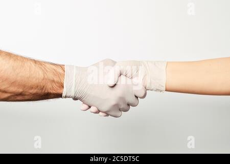 Uomo e donna scuotono le mani in guanti medici. Foto Stock