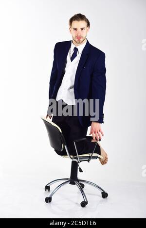Uomo bearded in costume formale godendo di pausa. Uomo con volto felice su sfondo bianco. Successo dei progetti e concetto di business agile. Un ragazzo con barba si diverte in sedia. Businessman o ceo di moda sorride. Foto Stock