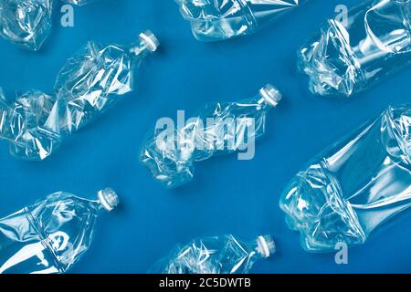 Molte bottiglie di plastica usate su sfondo blu. Il concetto di inquinamento del pianeta e degli oceani con rifiuti plastici. Foto Stock