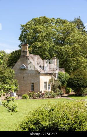 Un tipico cottage in pietra accanto alla strada Winchcombe sulle colline Cotswold vicino alla frazione di Farmcote, Gloucestershire UK Foto Stock