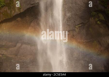 Un'immagine ravvicinata dell'arcobaleno sulla cascata Sekumpul a Bali, Indonesia Foto Stock