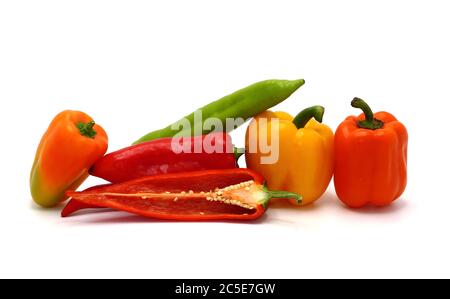 Composizione di diversi peperoni dolci e delle loro metà di colori diversi su uno sfondo chiaro. Prodotto naturale. Colore naturale. Primo piano. Foto Stock