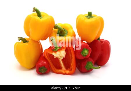 Composizione di diversi peperoni dolci e delle loro metà di colori diversi su uno sfondo chiaro. Prodotto naturale. Colore naturale. Primo piano. Foto Stock