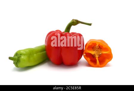 Composizione di diversi peperoni dolci e delle loro metà di colori diversi su uno sfondo chiaro. Prodotto naturale. Colore naturale. Primo piano. Foto Stock