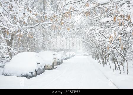 Strada durante la tempesta di neve in inverno a Mosca, Russia. Auto coperte di neve. Vista panoramica di una strada della città innevata. Mosca neve di fondo. sile freddo Foto Stock