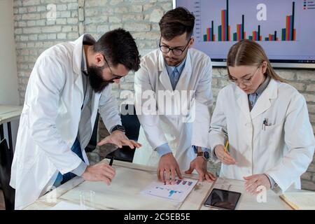 Medici e ricercatori medici in conferenza, discutendo possibili soluzioni per risolvere una crisi sanitaria mondiale. Foto Stock