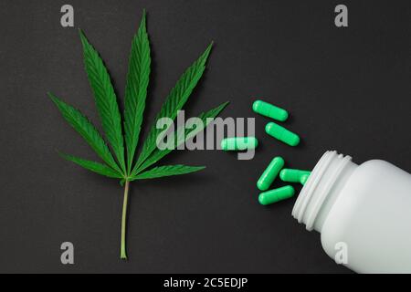 Cannabis, foglie di marijuana e pillole di medicina isolate su nero Foto Stock