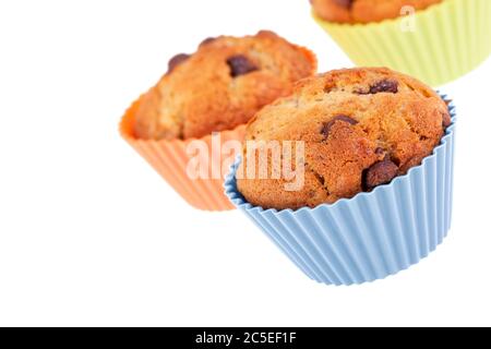 Tre muffin al cioccolato con chip alla banana in coloratissime custodie in silicone. Spazio per il testo. Foto Stock