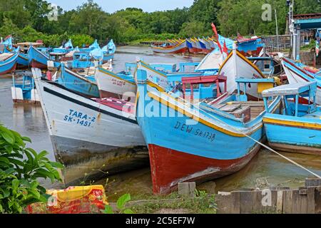 Colorate barche da pesca tradizionali in legno ormeggiate lungo la costa della Guyana, in Sud America Foto Stock