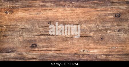 Sfondo di tessitura di legno. Vista dall'alto del tavolo di legno scuro d'epoca con una crepa. Legno rustico marrone ruvido per sfondo. Superficie di legno annodato vecchio con n Foto Stock