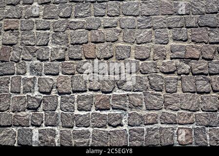 Fondo texture pavimentazione cobblestone. Vista dall'alto della strada in pietra. Dettaglio del marciapiede in granito preso dall'alto. Vecchie strade acciottolate per sfondo. AB Foto Stock