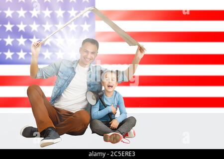 concetto di famiglia e di gente - felice sorridente padre e piccola figlia sopra la famiglia della bandiera degli stati uniti Foto Stock