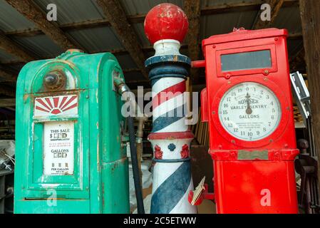 Idaho, USA - 22 agosto 2013: Un vecchio palo barbiere tra le pompe a gas antiche Foto Stock