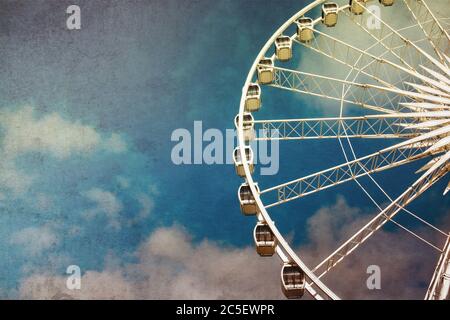 Immagine in stile retrò di una ruota in ferro contro il cielo blu. Effetto grunge a lavorazione incrociata. Foto Stock