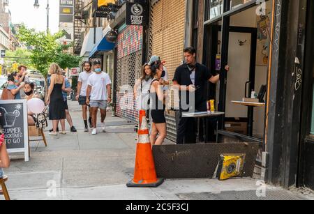 I clienti aspettano on line per un drink "grab and go" nel quartiere Lower East Side di New York sabato 20 giugno 2020. ( © Richard B. Levine) Foto Stock