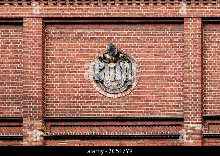 Un bassorilievo rotondo con un elmo crestato decora la facciata in mattoni della birreria Landskron a Görlitz, Sassonia. Fondata nel 1869 come Görlitzer Aktien-Brauerei, la birreria ha fatto erigere la maggior parte dei suoi edifici industriali in mattoni tra il 1907 e il 1916. Foto Stock