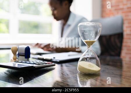 Black Accountant Woman lavora con fattura e clessidra Foto Stock