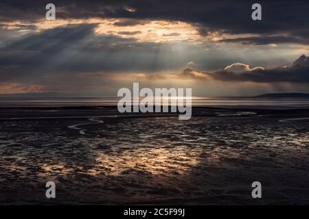 Alberi di luce che cadono dal cielo nero sulla spiaggia della baia di Morecambe a Bolton le Sands Foto Stock