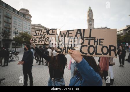 Porto, Portogallo - 6 giugno 2020: Manifestazione contro la discriminazione razziale la questione delle vite nere; due donne davanti alla folla che tengono cartelli Foto Stock