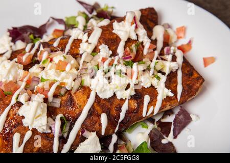 Piatto di delizioso enchilada di pollo messicano con salsa talpa e formaggio fuso Foto Stock