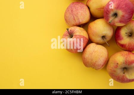 Mele rosse affiancate su fondo giallo. Sfondi naturali, frutta set Foto Stock