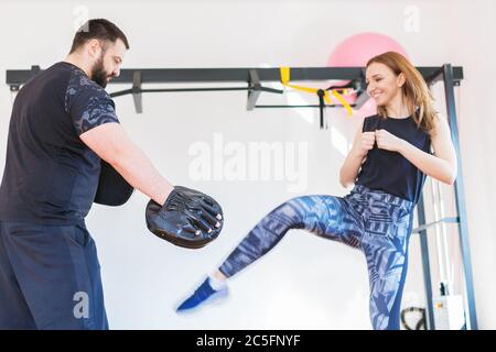 giovane donna che pugilato con personal trainer Foto Stock