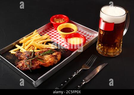 Deliziose ali di pollo fritte con patatine fritte e tre salse servite al ristorante Foto Stock