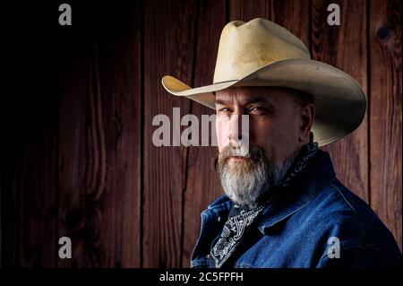 Uomo anziano con barba grigia e cappello da cowboy Foto Stock