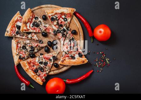 Concetto di pizza. Pizza ripiena di pomodori, pepe rosso, salame e olive Foto Stock