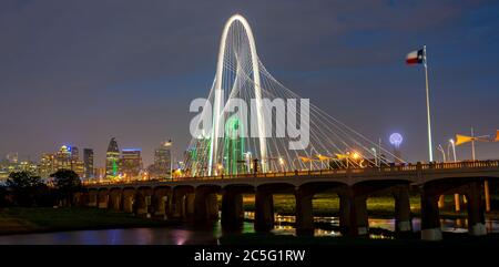 Vista del Ponte Margaret Hunt Hill di notte con la bandiera del Texas e la Torre Reunion sullo sfondo Foto Stock