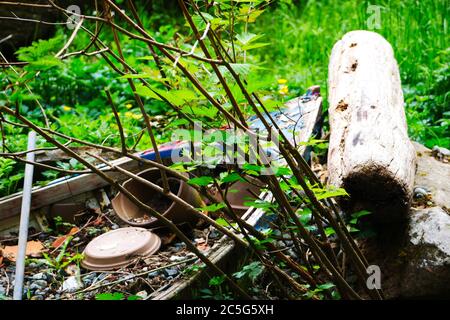 Vecchia barca e vasi di piante rotti in un giardino rustico Foto Stock
