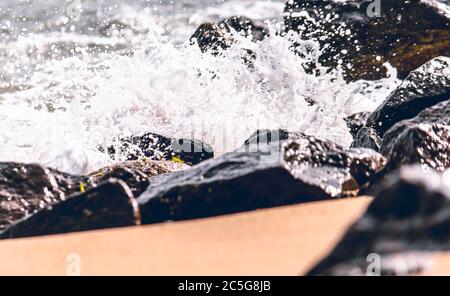 Onde dell'oceano che si infrangono in rocce nella foto della spiaggia della giungla di sabbia Foto Stock