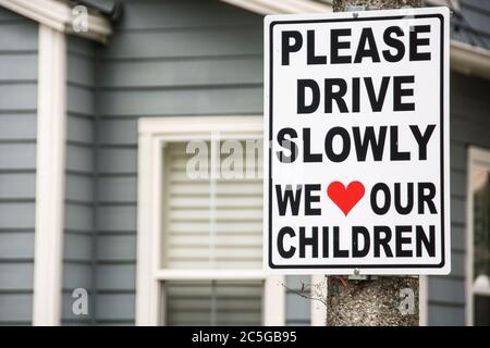 Un cartello su un posto in un quartiere a Mission Viejo, California, che dice: "Guidare lentamente. Amiamo i nostri figli." Foto Stock