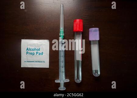 kit per la raccolta del sangue, siringa vuota con ago, provetta per il prelievo del sangue e tampone imbevuto di alcool, concetto medico Foto Stock