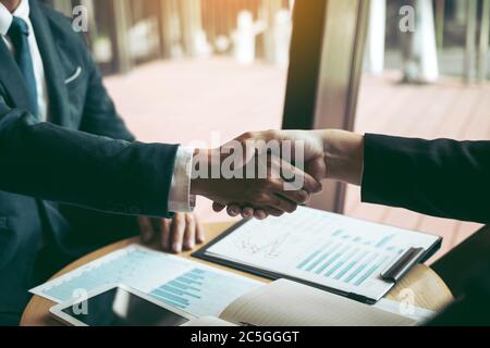 Gli uomini d'affari accettano o confermano il progetto sulla proposta e si uniscono a mani agitanti presso l'azienda della sala d'ufficio. Foto Stock